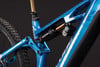 Detail der hinteren Federung eines blauen Mountainbikes mit Dämpfer.