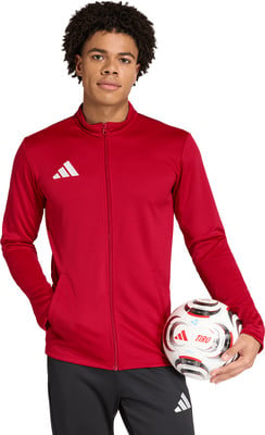 Junger Mann im roten Trainingsanzug mit einem Fußball in der Hand. Junger Mann im roten Trainingsanzug mit einem Fußball in der Hand.