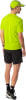 Ein Mann in einer reflektierenden gelben Jacke und schwarzen Shorts posiert von hinten.
