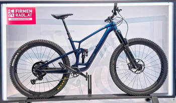Ein blaues Trek Full-Suspension Mountainbike auf einem Ausstellungsständer.