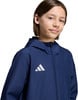Junge in dunkelblauer Adidas-Jacke lächelt in die Kamera.