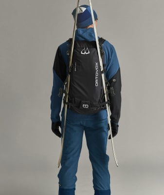 Rückansicht eines Skifahrers mit Rucksack und Skiern auf dem Rücken. Rückansicht eines Skifahrers mit Rucksack und Skiern auf dem Rücken.