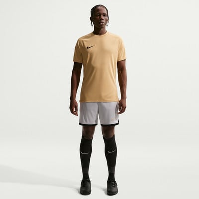 Ein Mann in einem beigefarbenen T-Shirt und grauen Shorts steht vor einem weißen Hintergrund. Ein Mann in einem beigefarbenen T-Shirt und grauen Shorts steht vor einem weißen Hintergrund.