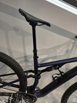 Teil eines dunkelblauen Mountainbikes mit Dämpfer und Sattelstütze.