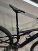 Teil eines dunkelblauen Mountainbikes mit Dämpfer und Sattelstütze.