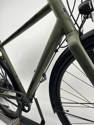 Grünes Cube Fahrrad mit TRAVEL Schriftzug und Riemenantrieb.