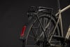 Schwarzer Gepäckträger und Schutzblech an einem Fahrrad mit Reflektor.