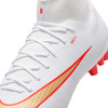Weißer Fußballschuh mit rot-goldenem Nike-Logo und roten Stollen.