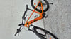 Ein orangefarbenes KTM E-Bike auf einer grauen, kiesartigen Oberfläche.