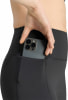Eine Frau verstaut ihr Handy in der praktischen Seitentasche einer Leggings.