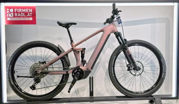 Ein rosafarbenes E-Bike mit Federung ist auf einem Ständer ausgestellt.