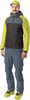 Ein Mann in Skibekleidung mit Jacke und Hose mit Skischuhen.
