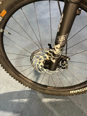 Nahaufnahme eines Mountainbike-Vorderrads mit Scheibenbremse und Federgabel. Nahaufnahme eines Mountainbike-Vorderrads mit Scheibenbremse und Federgabel.