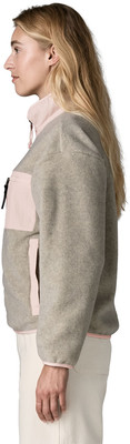 Frau in beigem Fleece-Pullover mit rosa Details, im Profil. Frau in beigem Fleece-Pullover mit rosa Details, im Profil.