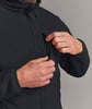 Ein Mann verstellt den Reißverschluss einer dunklen Jacke, seine Hände sind nahe der Tasche.