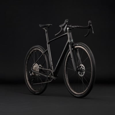 Ein schwarzes Gravelbike mit Scheibenbremsen und breiten Reifen vor schwarzem Hintergrund. Ein schwarzes Gravelbike mit Scheibenbremsen und breiten Reifen vor schwarzem Hintergrund.