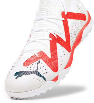 Weißer Fußballschuh mit roten und dunkelblauen Akzenten und Puma-Logo. Weißer Fußballschuh mit roten und dunkelblauen Akzenten und Puma-Logo.