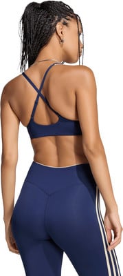 Frau in dunkelblauem Sport-BH und Leggings mit Streifen. Frau in dunkelblauem Sport-BH und Leggings mit Streifen.