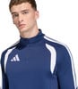 Ein Mann in einem dunkelblauen Sportshirt mit weißen Streifen und Adidas-Logo.
