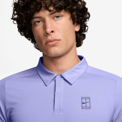 Ein Mann in einem lila Poloshirt mit Nike-Logo.
