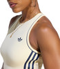 Eine Frau in einem cremefarbenen Oberteil mit dunkelblauen Streifen und Adidas-Logo.