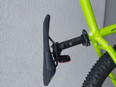 Ein grünes Fahrrad mit schwarzem Sattel und rotem Licht an der Sattelstütze. Ein grünes Fahrrad mit schwarzem Sattel und rotem Licht an der Sattelstütze.