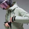 Eine Frau in einer Skijacke und einem Helm passt ihre Tasche an.