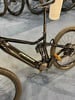 Schwarzes Merida Mountain-E-Bike mit Federung und goldenen Pedalen.