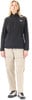 Frau in schwarzem Fleece-Pullover und beiger Cargohose.