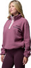 Eine Frau trägt einen rosa Teddy-Pullover mit Kragen und dunkelviolette Leggings.