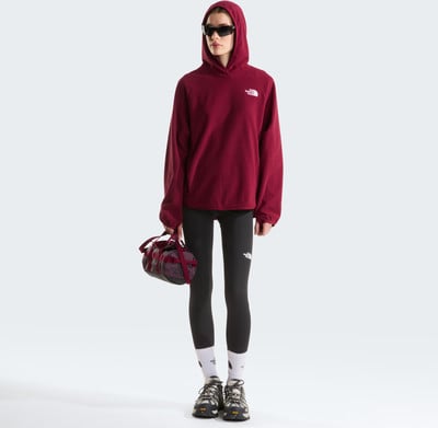 Damen-Weinrote Kapuzen-Sweatshirt und schwarze Leggings, hält eine kleine Tasche. Damen-Weinrote Kapuzen-Sweatshirt und schwarze Leggings, hält eine kleine Tasche.