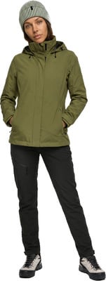 Eine Frau in einer grünen Jacke und schwarzer Hose mit Mütze Eine Frau in einer grünen Jacke und schwarzer Hose mit Mütze