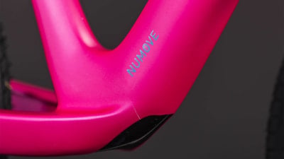 Ein pinker Fahrradrahmen mit dem NUMOVE-Logo, Nahaufnahme. Ein pinker Fahrradrahmen mit dem NUMOVE-Logo, Nahaufnahme.