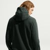 Rückansicht eines Mannes mit langen Haaren in einem dunkelgrünen Kapuzenpullover.