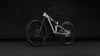 Ein mintgrünes Fullsuspension-E-Bike mit schwarzen Details vor dunklem Hintergrund.