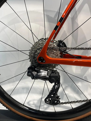 Shimano GRX Schaltwerk an orangefarbenem Fahrradrahmen mit Kassette. Shimano GRX Schaltwerk an orangefarbenem Fahrradrahmen mit Kassette.