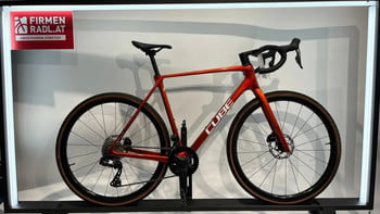 Oranges Cube Gravelbike mit schwarzem Lenker und braunen Reifen.