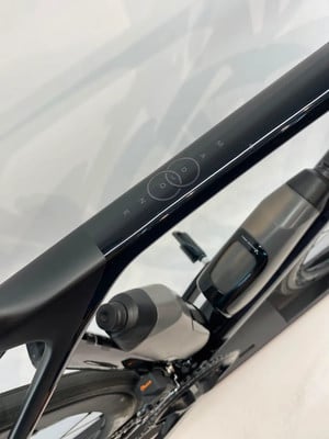 Schwarze Rennrad-Trinkflasche mit Logo am Fahrradrahmen. Schwarze Rennrad-Trinkflasche mit Logo am Fahrradrahmen.