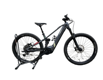 Graues E-Mountainbike auf Ständer mit Vorder- und Hinterradfederung.