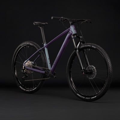 Lila Mountainbike mit schwarzen Rädern und Federung auf dunklem Hintergrund. Lila Mountainbike mit schwarzen Rädern und Federung auf dunklem Hintergrund.