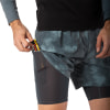 Ein Mann steckt einen Energieriegel in die Tasche einer Shorts mit integrierten Leggings.