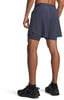 Mann in dunkelblauen Shorts mit integrierten Leggings und schwarzen Turnschuhen.