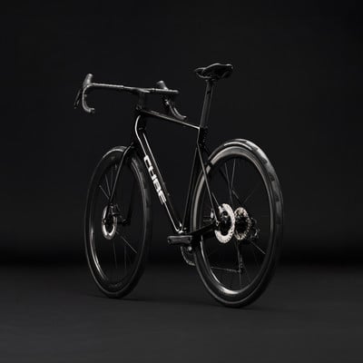 Schwarzes Cube Rennrad mit Scheibenbremsen auf schwarzem Hintergrund. Schwarzes Cube Rennrad mit Scheibenbremsen auf schwarzem Hintergrund.