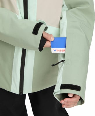 Grüne Jacke mit Ärmeltasche, in die eine Karte gesteckt wird. Grüne Jacke mit Ärmeltasche, in die eine Karte gesteckt wird.