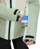 Grüne Jacke mit Ärmeltasche, in die eine Karte gesteckt wird.