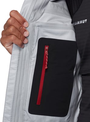 Innentasche der Jacke mit rotem Reißverschluss und Mammut-Logo. Innentasche der Jacke mit rotem Reißverschluss und Mammut-Logo.