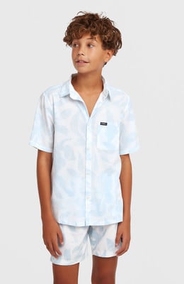 Junge in weißem Hemd mit blauem Blattmuster und Shorts. Junge in weißem Hemd mit blauem Blattmuster und Shorts.