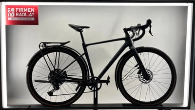Schwarzes Gravelbike mit Schutzblechen und Gepäckträger vor weißem Hintergrund.