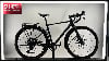 Schwarzes Gravelbike mit Schutzblechen und Gepäckträger vor weißem Hintergrund.