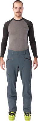 Mann in grauem Langarmshirt und dunkelblauen Skihose mit Skischuhen. Mann in grauem Langarmshirt und dunkelblauen Skihose mit Skischuhen.